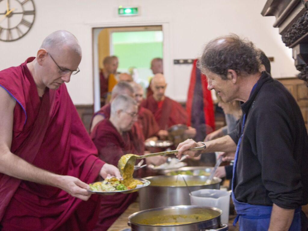 A student serves at the buffet at Institut Vajra Yogini