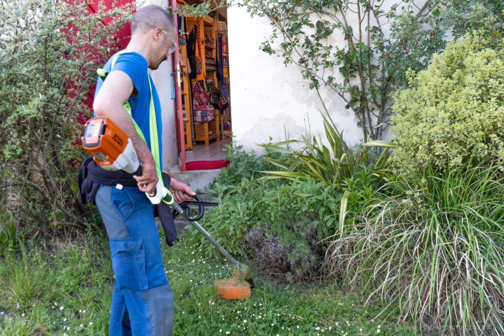 A man uses the mower at the Institut Vajra Yogini